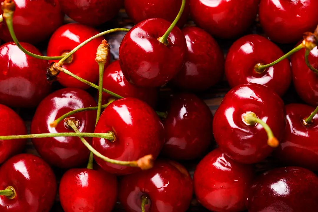 What specific pigments are responsible for giving darker cherry varieties their deep red or purple hue?