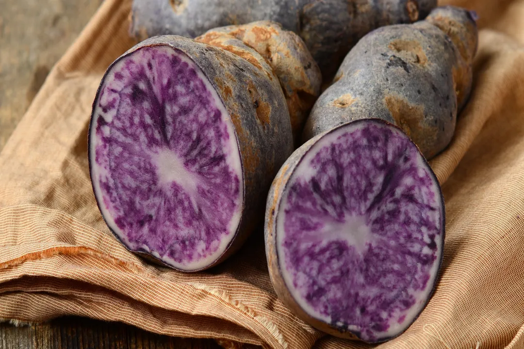 According to research comparing purple-fleshed and white-fleshed potatoes, how much greater was the antioxidant activity observed in the purple variety when measured gram-for-gram?